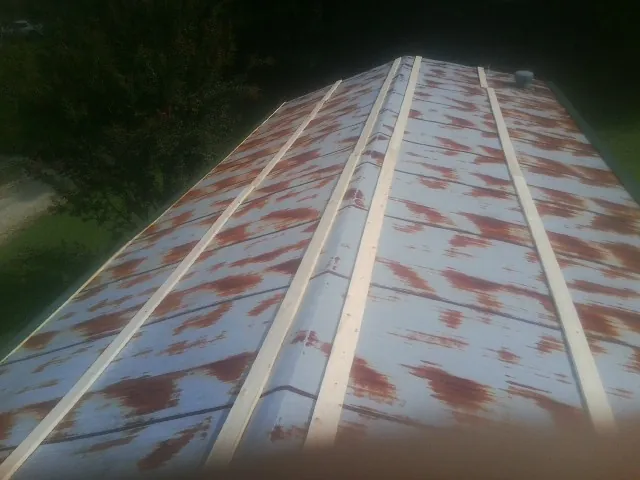 Rusted metal roof panels with new wood purlins before replacement — Storm Damage Roof Repair in Girard by Roofing Brothers