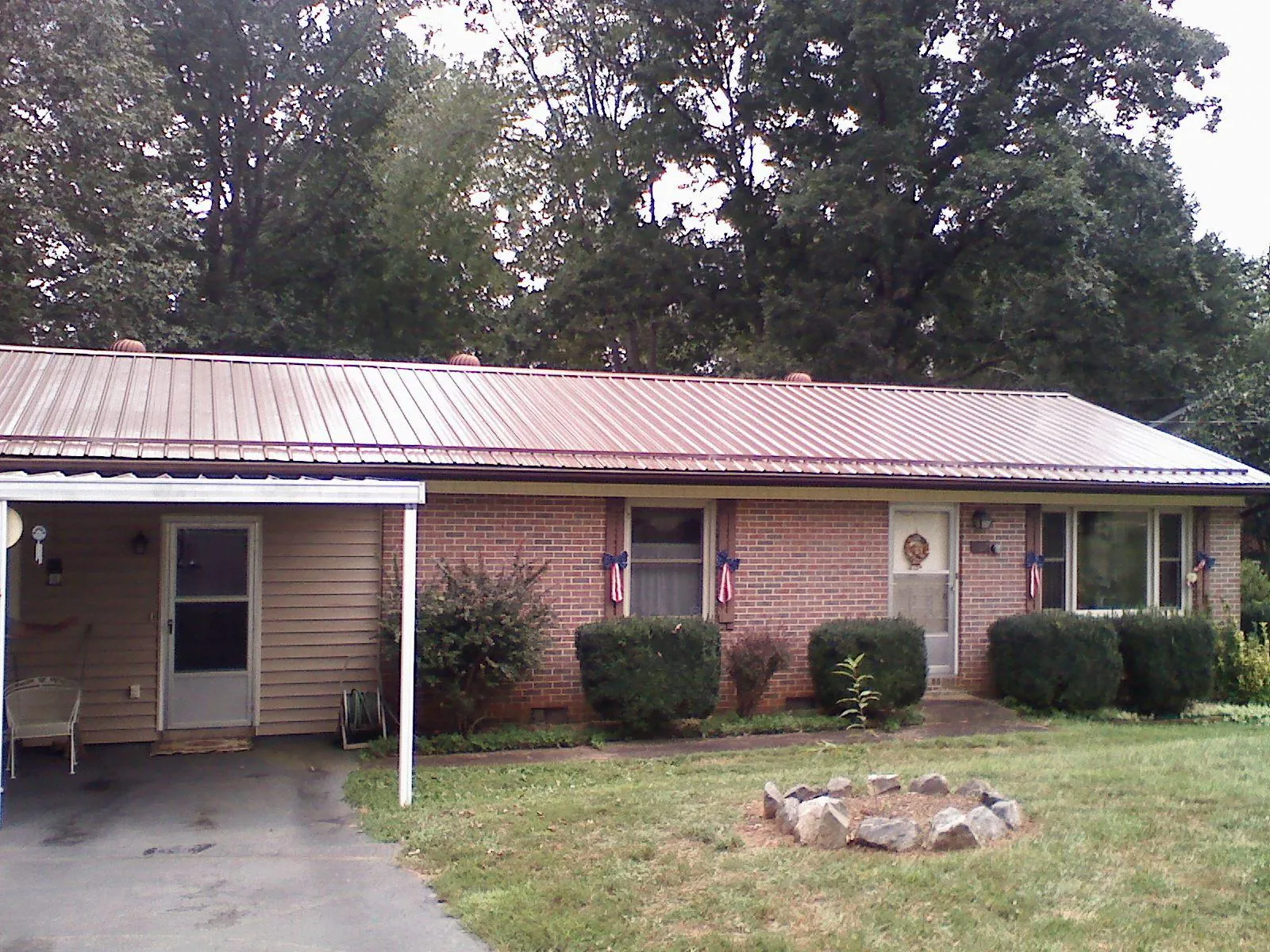 Bronze metal roof and carport on a brick ranch home — Roof Repair work by our crew in Girard